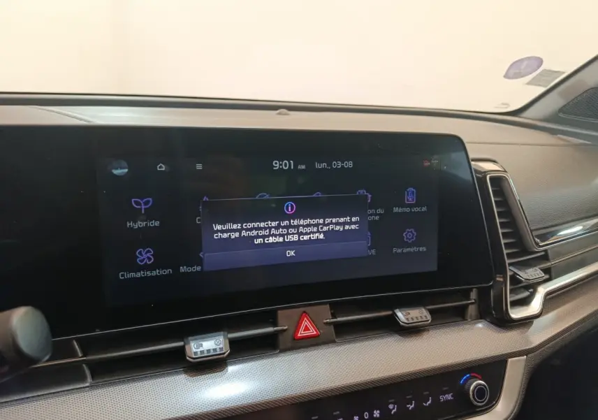 Vue rapprochée de l’écran tactile central du tableau de bord du Kia Sportage gris clair avec message de connexion Android Auto/Apple CarPlay.