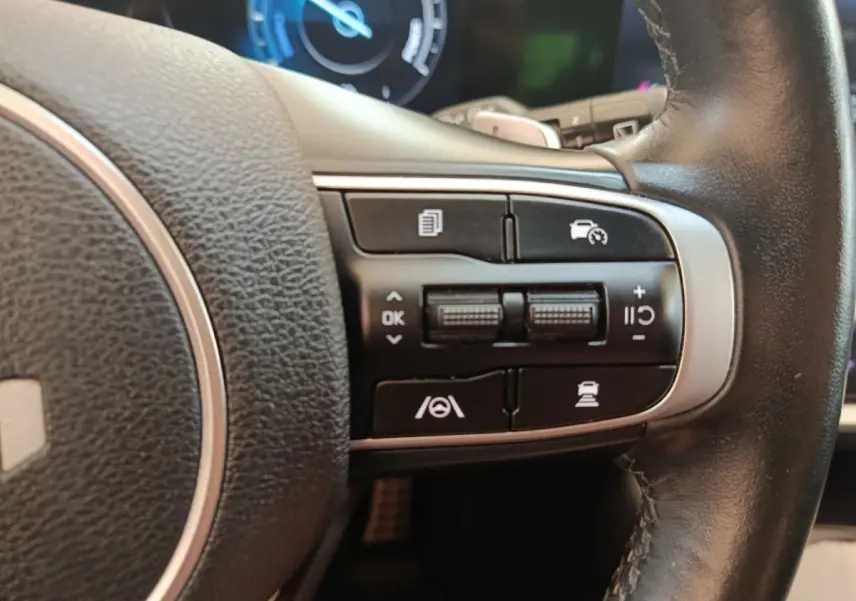 Gros plan sur les commandes multifonctions à droite du volant cuir noir du Kia Sportage gris clair 2022.
