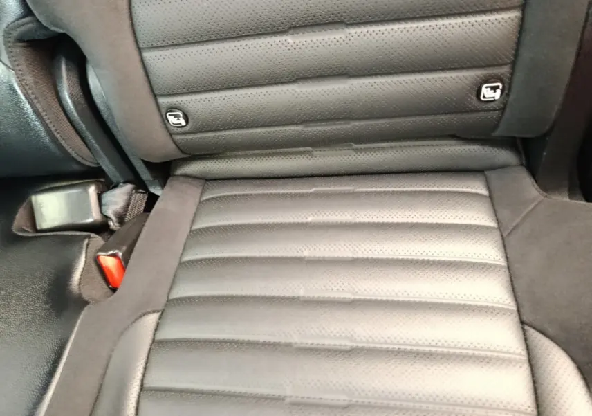 Gros plan sur l'assise arrière en cuir noir perforé du Kia Sportage 2022, avec fixation Isofix visible.