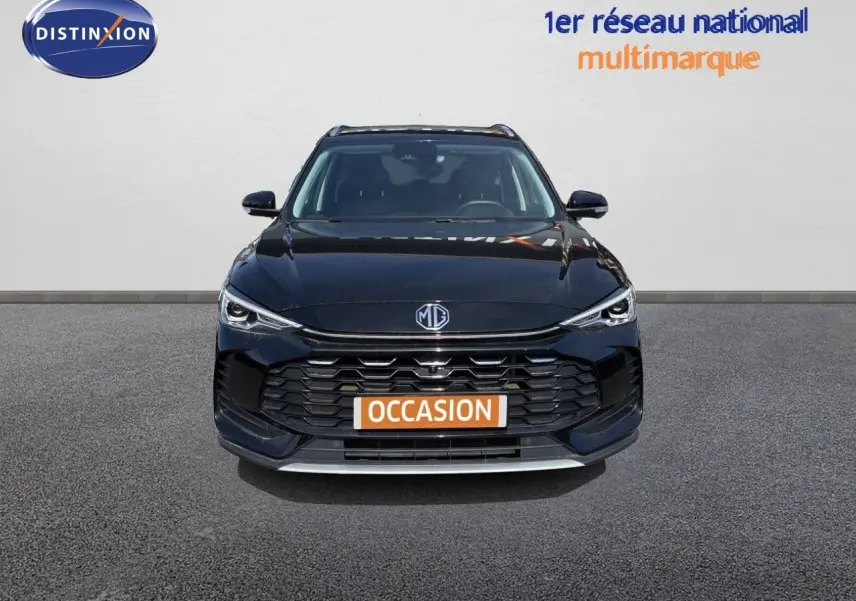 Vue frontale d'un MG ZS 1.5L Hybrid+ 197ch Luxury noir Pebble Black Metal avec calandre large et phares LED fins.