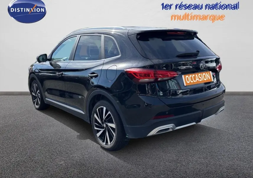Vue 3/4 arrière droite du SUV MG ZS 1.5L Hybrid+ 197ch Luxury en noir Pebble Black Metal avec jantes alliage bicolores.