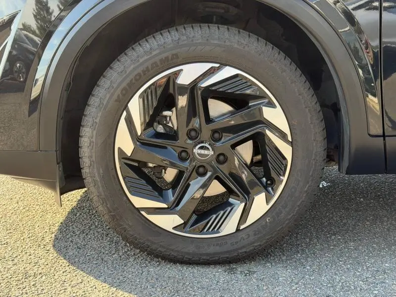 Gros plan sur la roue avant gauche du Nissan Qashqai 2025 noir Kuro Métallisé avec jante alliage noire et argent.