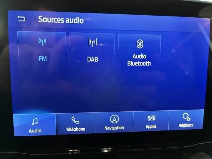 Écran tactile du système multimédia Ford Puma 2022 affichant les sources audio FM, DAB et Bluetooth.