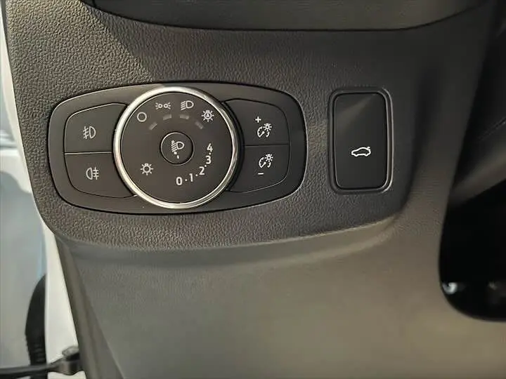 Gros plan sur les commandes d'éclairage et ouverture du coffre du Ford Puma blanc glacier 2022 côté gauche intérieur.