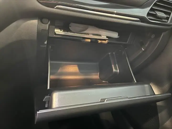 Gros plan sur la boîte à gants ouverte de la Ford Puma blanc glacier, montrant l'intérieur du compartiment passager.