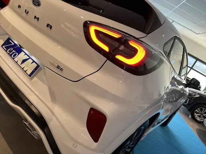 Vue 3/4 arrière droite d'une Ford Puma blanc glacier avec feux arrière allumés en forme de C.