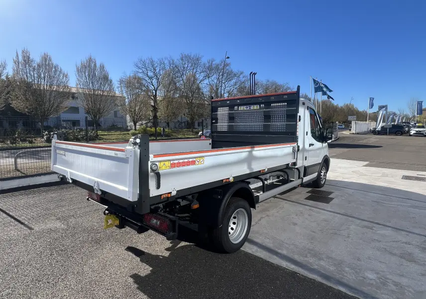 Ford Transit Chassis cabine blanc vu 3/4 arrière droit avec benne et coffre, roues jumelées et pare-éclats noir.