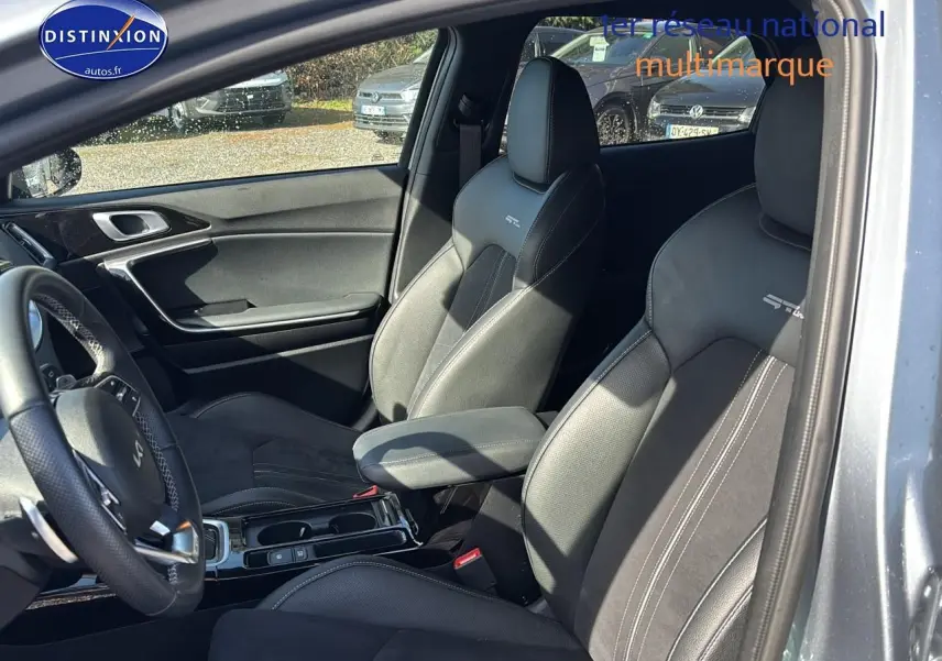 Vue intérieure côté conducteur du Kia Xceed gris 2024, sièges sport GT-Line avec surpiqûres blanches et accoudoir central.