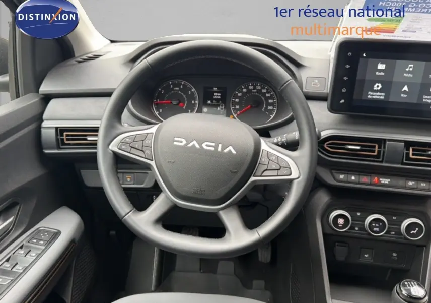 Vue intérieure centrée sur le volant DACIA du Jogger 2026, tableau de bord et écran tactile visibles, ambiance sobre et fonctionnelle.
