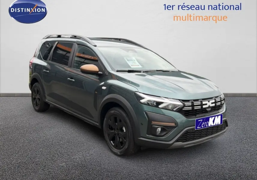 Vue 3/4 avant gauche d'une Dacia Jogger 2026 vert cèdre métallisé avec rétroviseurs couleur beige et jantes noires.
