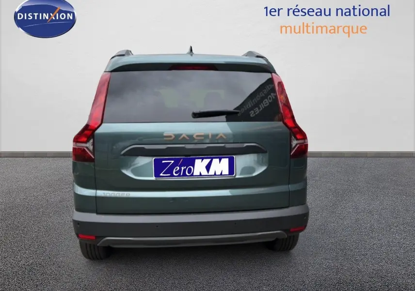 Vue arrière d'un Dacia Jogger vert cèdre métal avec feux arrière en L et logo DACIA visible.