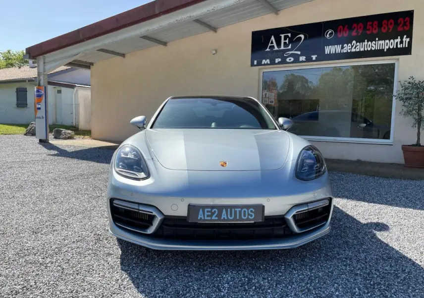 Vue frontale d'une Porsche Panamera 4 V6 3.0 Hybrid Platinum Edition gris métallisé, avec calandre et phares distinctifs.