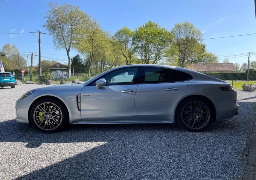 Vue latérale droite d'une Porsche Panamera 4 V6 3.0 Hybrid Platinum Edition gris métallisé, avec jantes sport et freins verts.