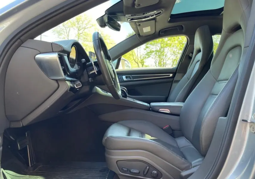 Vue intérieure côté conducteur de la Porsche Panamera 4 V6 Hybrid 2022 avec sièges cuir gris et toit ouvrant panoramique.