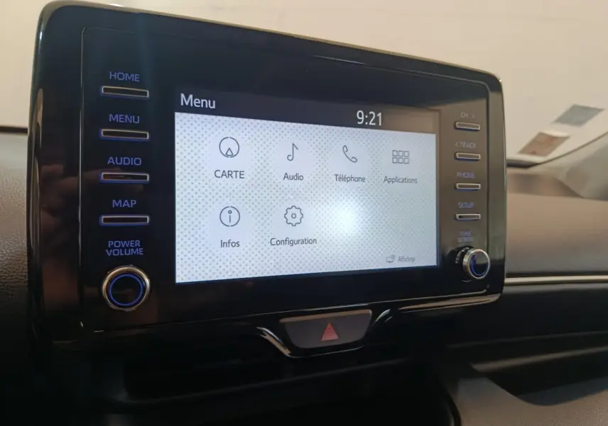 Écran tactile central de la Toyota Yaris hybride 2022, affichant le menu principal avec commandes latérales.
