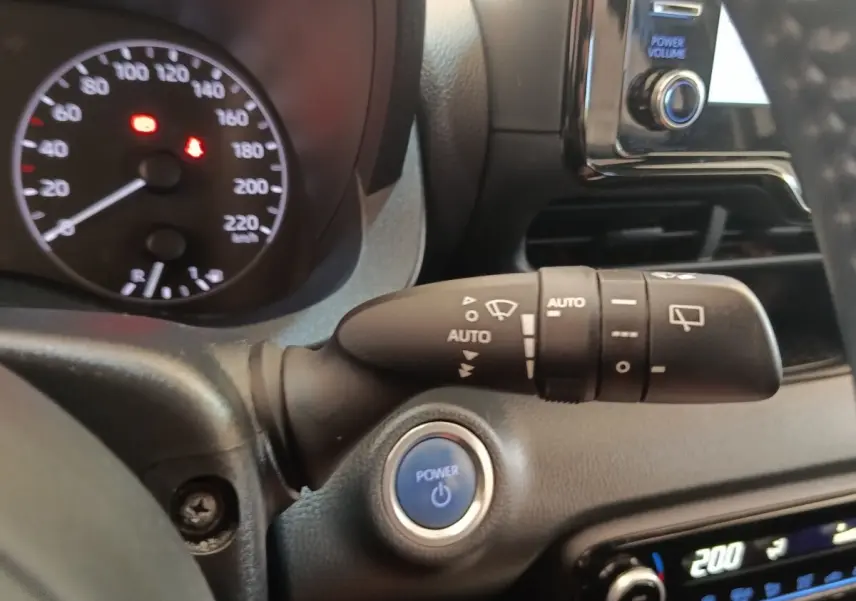 Gros plan intérieur sur la commande d’essuie-glace et bouton Power d’une Toyota Yaris Hybride blanche de 2022.