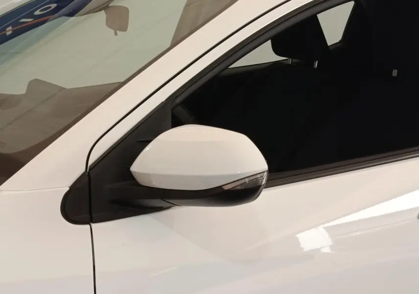 Rétroviseur côté gauche blanc de la Toyota Yaris Hybride 2022, vue rapprochée sur la portière avant.