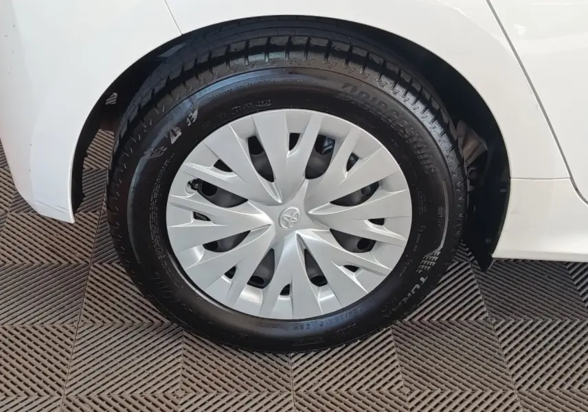 Gros plan sur la roue avant gauche blanche d’une Toyota Yaris hybride 2022 avec enjoliveur gris et pneu Bridgestone.