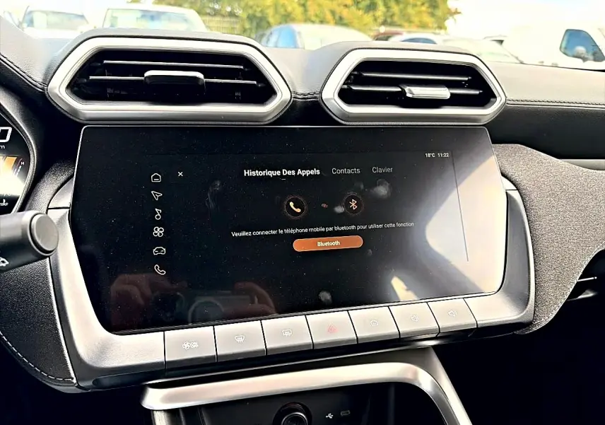 Vue rapprochée de l’écran tactile et des aérateurs hexagonaux du tableau de bord du MG Motor ZS Camden grey hybride 2026.
