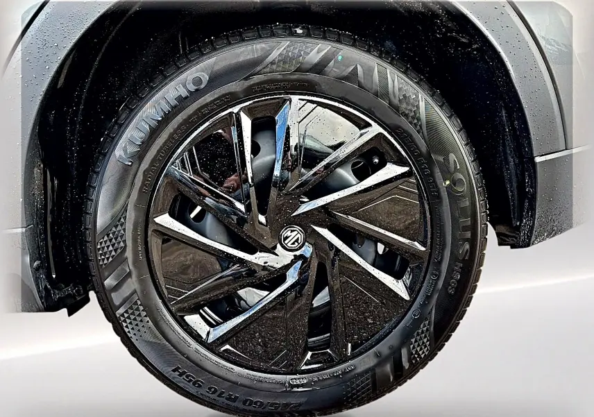 Gros plan sur la roue avant droite du MG ZS Camden grey, jante alliage noire brillante avec logo MG au centre.