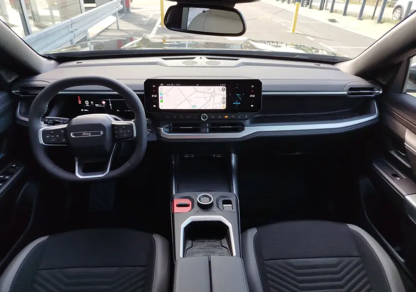 Vue intérieure frontale du tableau de bord et volant noir du Jeep Compass 2026 avec écran tactile central et finitions modernes.