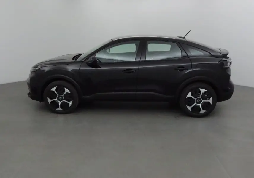 Profil côté gauche d'une Citroën C4 noire 2025 avec jantes au design moderne et toit légèrement incliné.