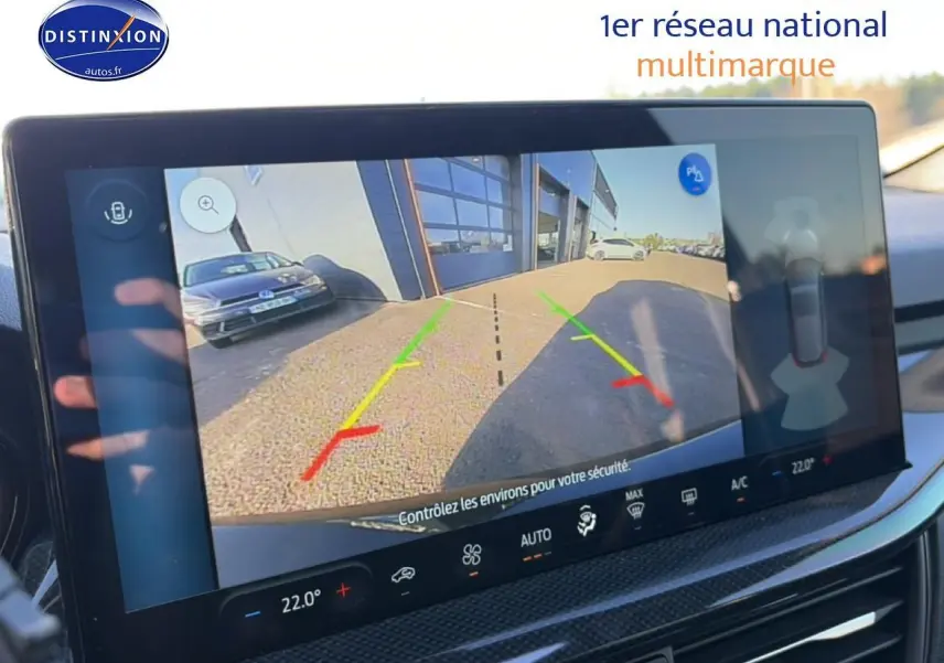Écran tactile intérieur montrant la caméra de recul d'une Ford Focus noire 2024 avec lignes de guidage colorées.