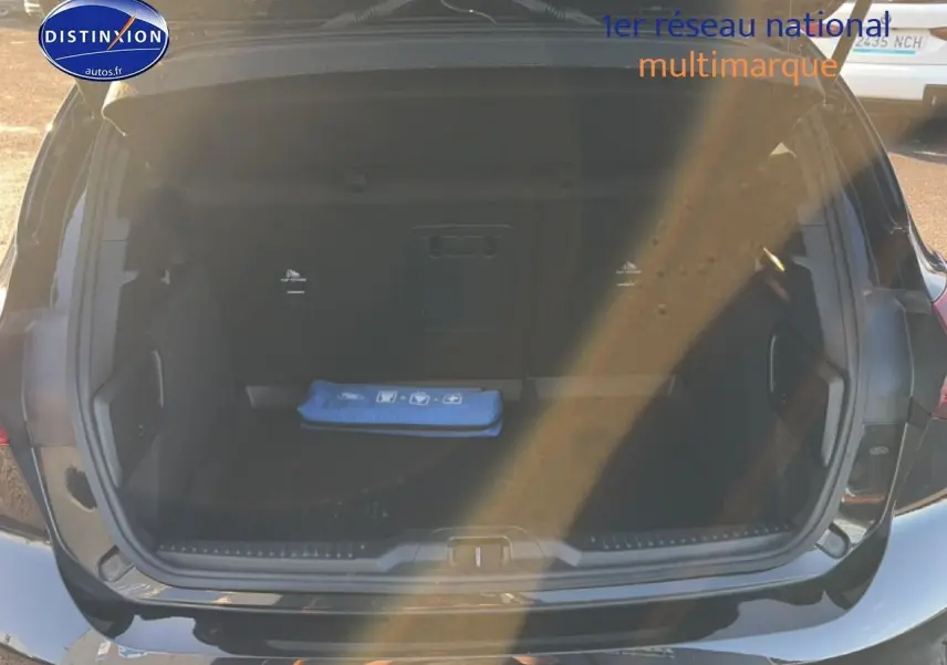 Coffre ouvert vu de l'arrière d'une Ford Focus noire 2024, avec trousse de secours bleue visible à l'intérieur.