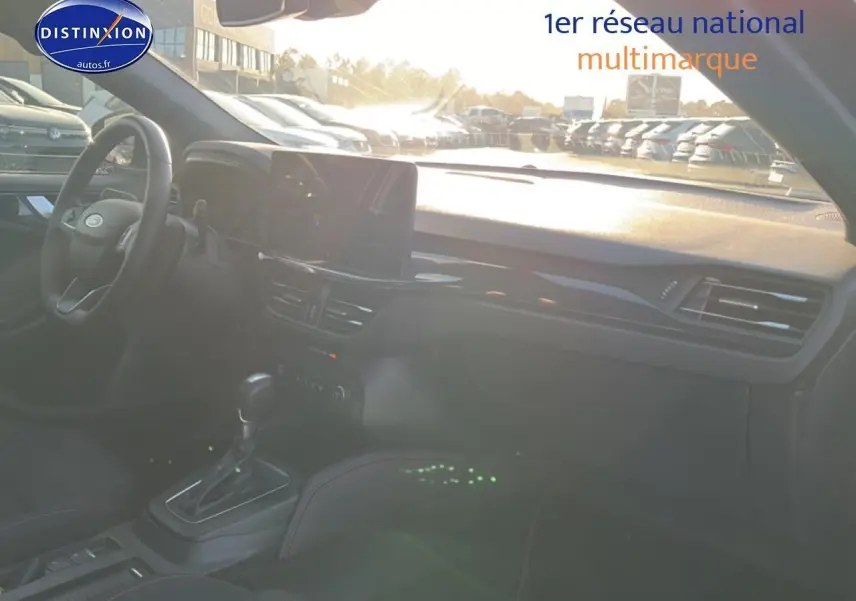 Vue intérieure côté conducteur de la Ford Focus noire 2024, mettant en valeur le tableau de bord et la console centrale.