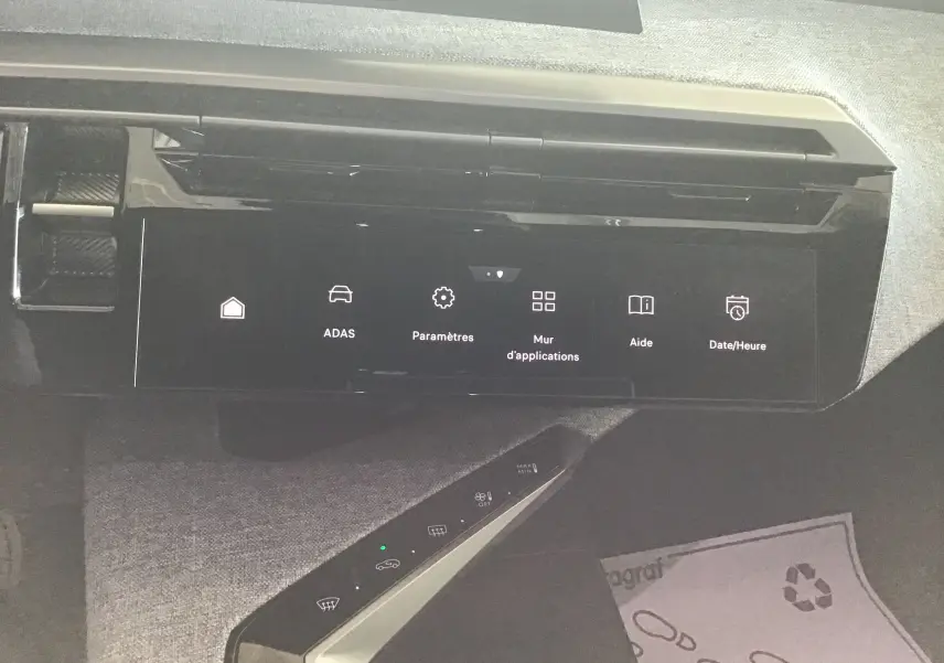 Vue rapprochée de l’écran tactile central noir du Peugeot 3008 gris titane, affichant le menu des paramètres et aides.