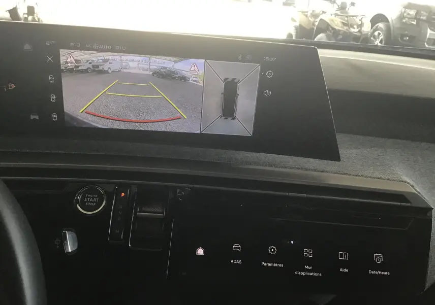 Vue intérieure du tableau de bord du Peugeot 3008 gris titane 2026, avec affichage caméra 360° et aide au stationnement.
