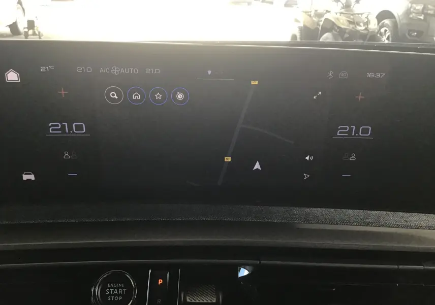 Vue rapprochée de l'écran tactile central du Peugeot 3008 gris titane, affichant la navigation et la climatisation à 21°C.