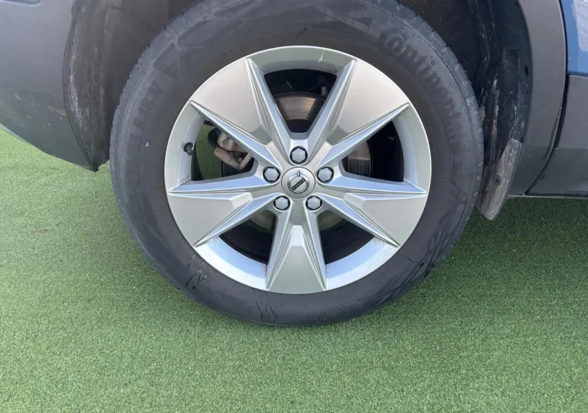 Gros plan sur la jante alliage 18 pouces argentée du Volvo XC40 Fjord Blue, avec pneu Continental visible.