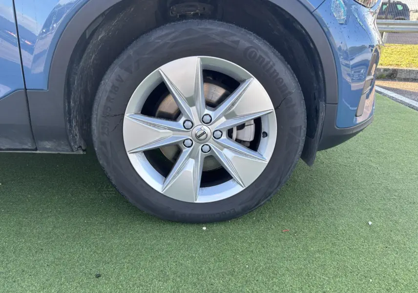 Gros plan sur la roue avant gauche avec jante alliage 18 pouces du Volvo XC40 Fjord Blue Metal.