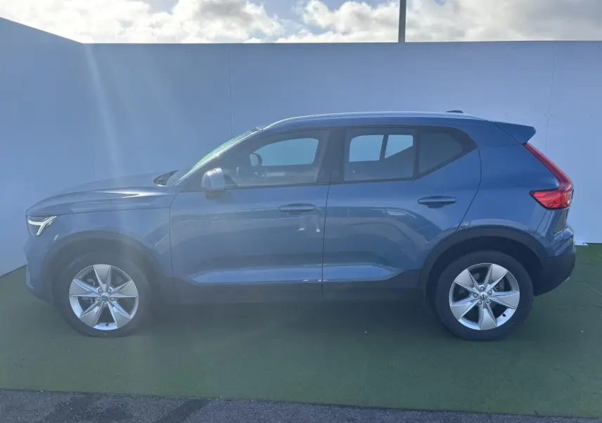 Profil côté gauche d'un Volvo XC40 Fjord Blue Metal 2024 avec jantes alliage 18 pouces et feux arrière LED.