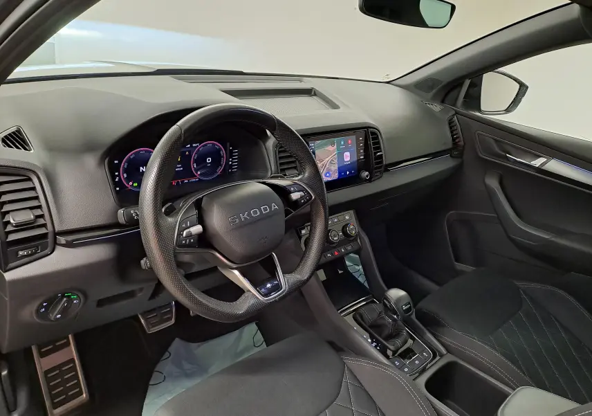 Vue intérieure côté conducteur du Skoda Karoq 2.0 TDI 150 DSG7 Sportline avec tableau de bord numérique et sellerie noire.