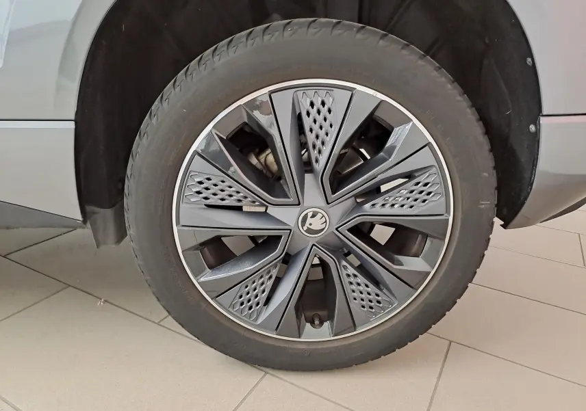 Gros plan sur la roue avant droite du Skoda Karoq 2025 gris graphite, mettant en valeur la jante design Sportline.