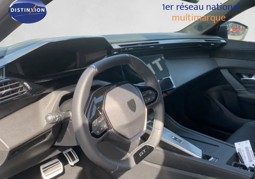 Vue intérieure côté conducteur du Peugeot 308 Hybrid blanc, avec volant compact GT et tableau de bord moderne.