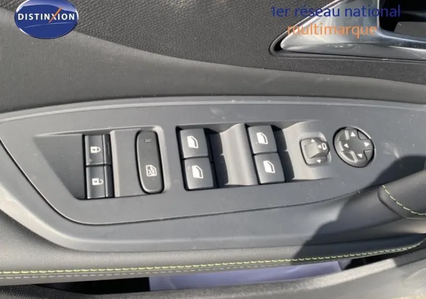 Gros plan sur les commandes de lève-vitres et rétroviseurs côté conducteur d’une Peugeot 308 Hybrid blanche, intérieur noir.