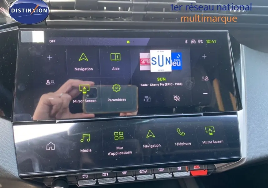 Écran tactile central de la Peugeot 308 Hybrid blanche, affichant le menu de navigation et multimédia.