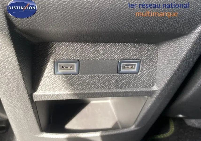 Gros plan sur deux ports USB-C intégrés dans la console centrale d'une Peugeot 308 Hybrid blanche.