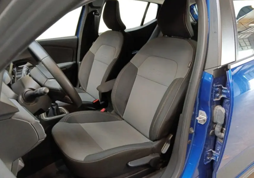 Vue intérieure côté conducteur de la Dacia Sandero Stepway 2025 bleu iron, montrant les sièges et le volant.
