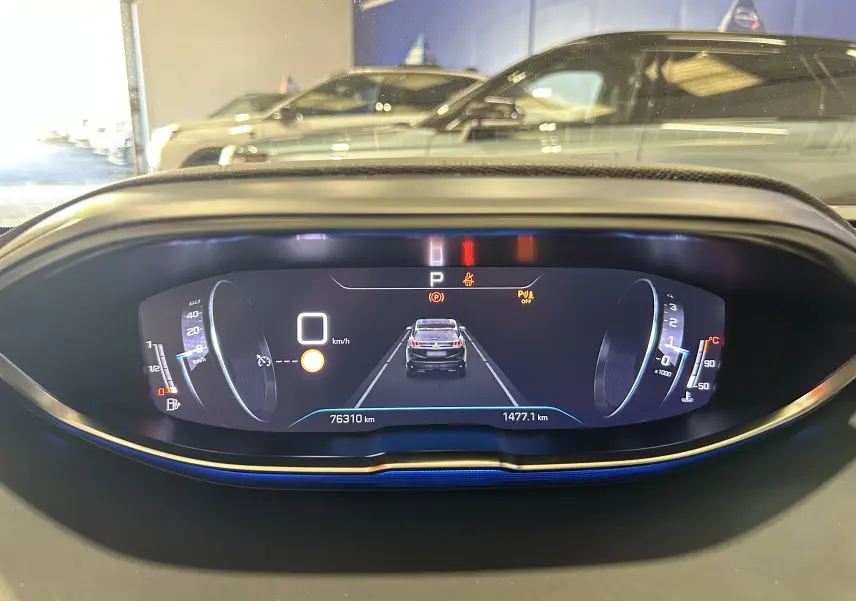 Tableau de bord numérique du Peugeot 3008 gris Platinium, affichant la vitesse à 0 km/h et l'assistance au stationnement.