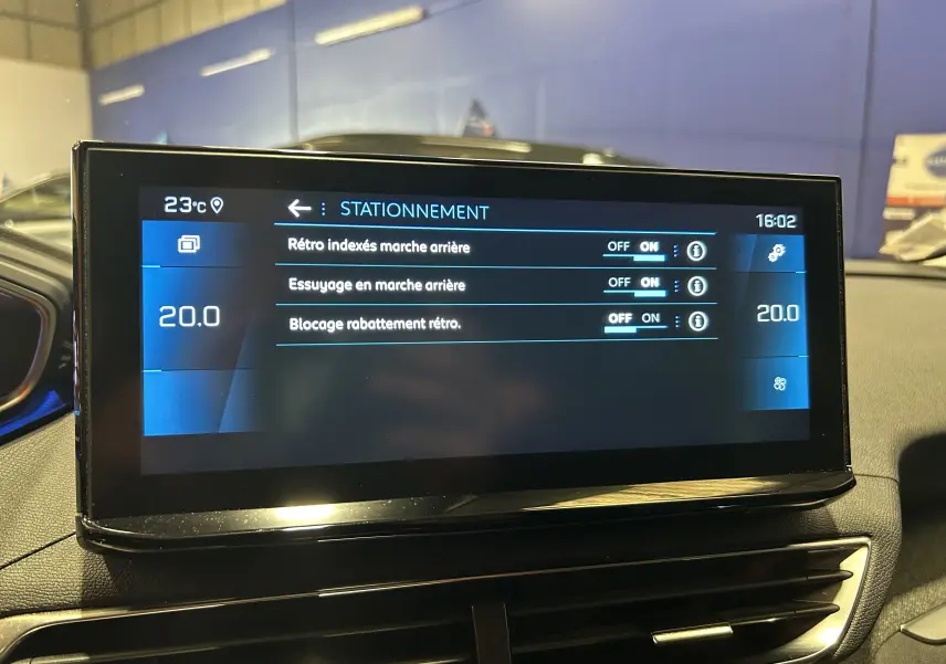 Écran tactile central du Peugeot 3008 II Ph.2, affichant les réglages de stationnement avec interface moderne et éclairage intérieur.