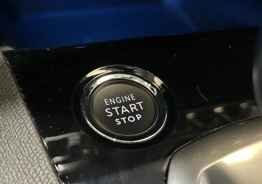 Gros plan sur le bouton start/stop du moteur dans l'habitacle du Peugeot 3008 gris Platinium, version 2022.