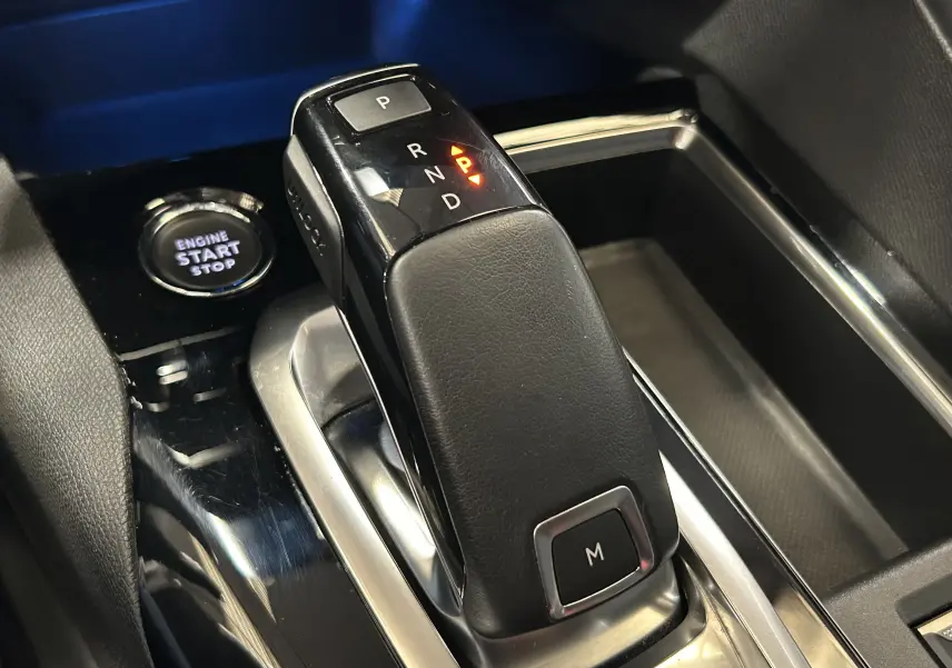 Gros plan sur le levier de vitesses automatique noir et argenté du Peugeot 3008 II Ph.2, avec bouton start/stop visible.