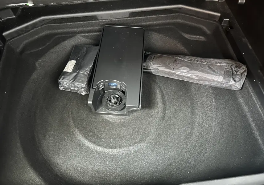 Coffre ouvert d’un Peugeot 3008 gris Platinium, vue plongeante sur espace de rangement avec accessoires rangés.