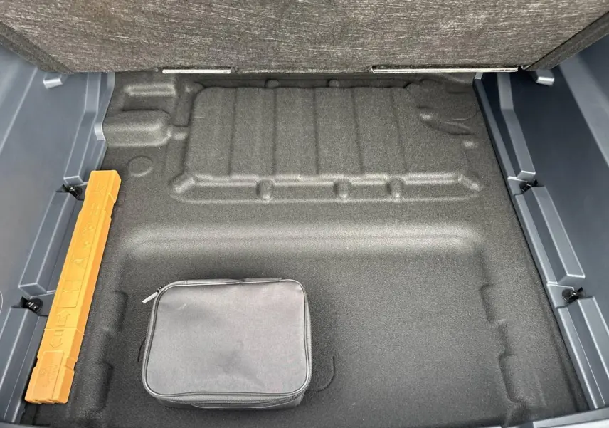 Vue plongeante sur le coffre vide du Geely STARRAY 1.5 EM-i 262ch Max+ en Volcanic Grey Metallic, avec trousse noire.