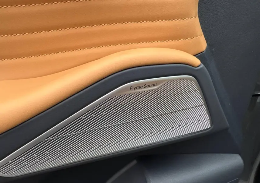 Gros plan sur haut-parleur Flyme Sound intégré dans la porte intérieure marron clair du GEELY STARRAY 2026.