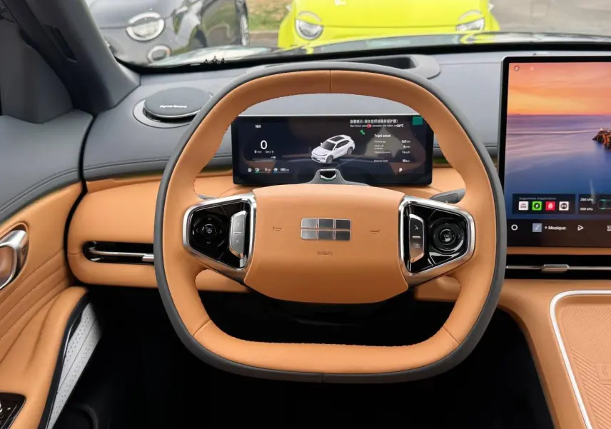 Vue intérieure centrée sur le volant carré cuir beige du Geely STARRAY avec tableau de bord numérique et écran tactile.